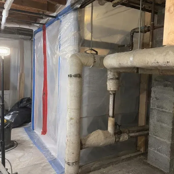 Pipework sealed in plastic containment during asbestos abatement