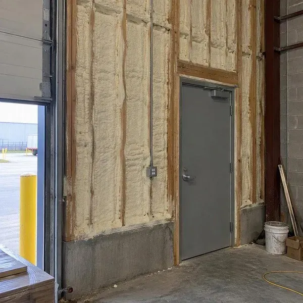 Spray foam insulated walls beside a commercial service door