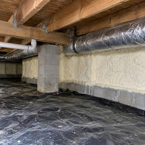 Crawl space walls insulated above a sealed poly ground cover