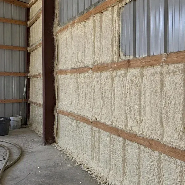 Spray foam covering corrugated metal building wall panels